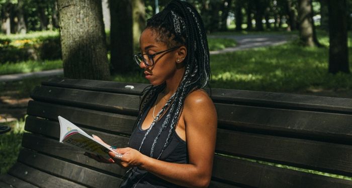 a brown skinned Black woman on a park bench.jpg.optimal