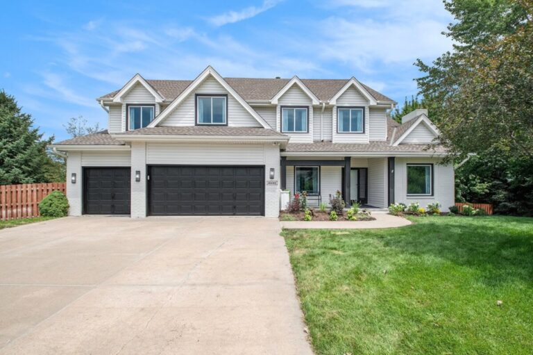 white single family home with black garage doors and large driveway