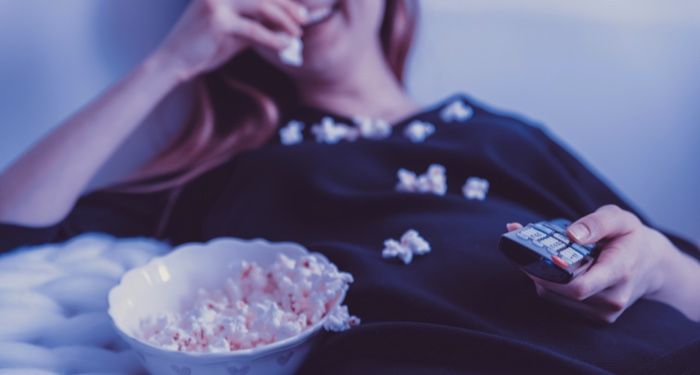 woman watching television and eating popcorn for film and tv feature 700x375 1.jpg.optimal